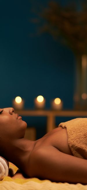Side view of young woman enjoying massage in luxury spa resort