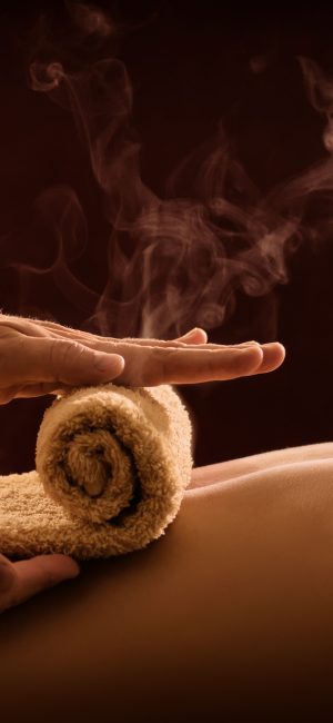 A professional therapist applies a hot towel on the back of a man. Hot towel compress. SPA treatment